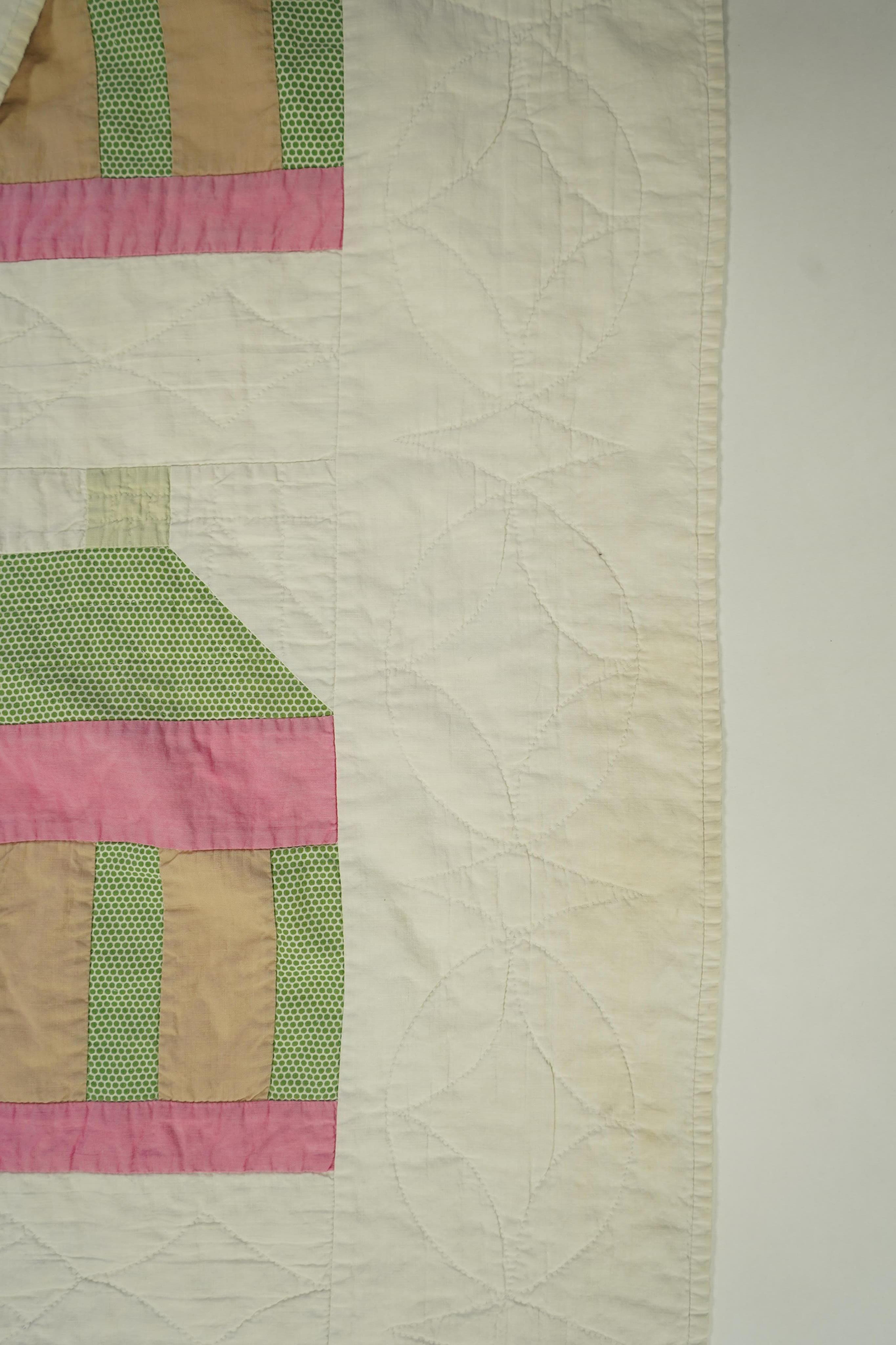A 1930’s American quilt from Vermont. Quilted in large patchwork ‘house’ motifs, repeating the same four colours in each motif against a plain white background. The reverse a plain white quilted cotton . The quilt hand p